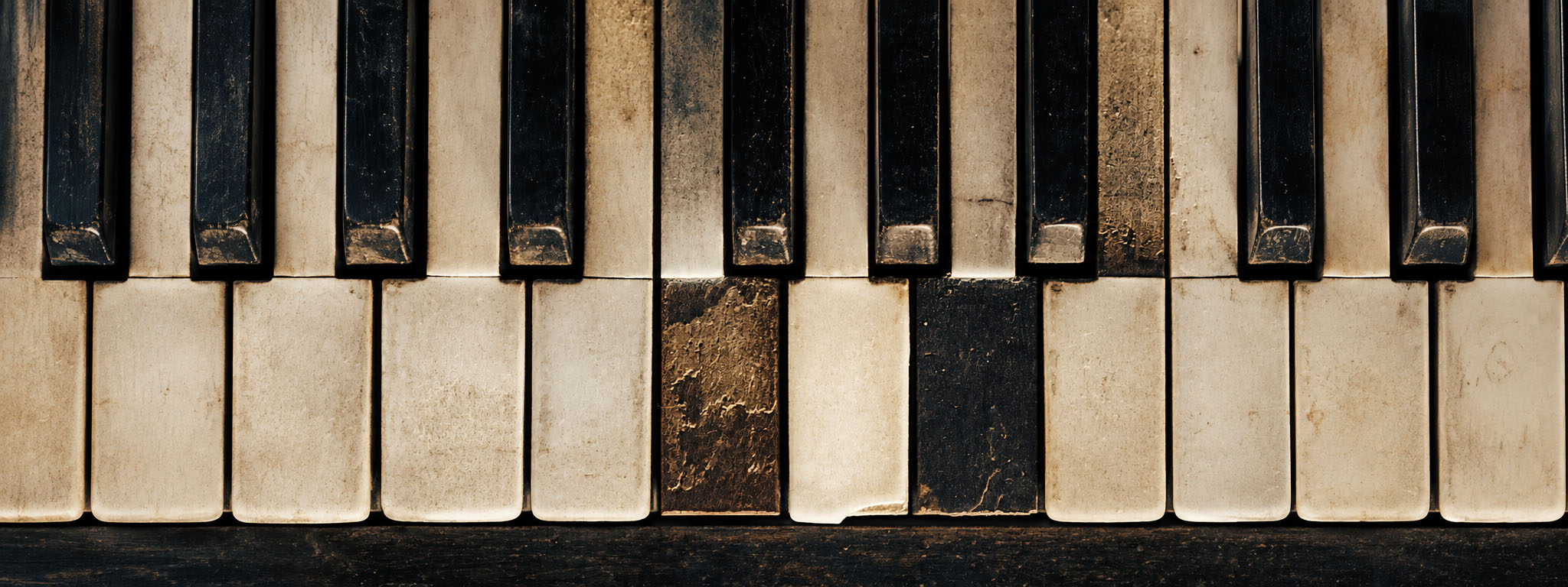 Close-up of the worn, weathered keys of an old piano.
